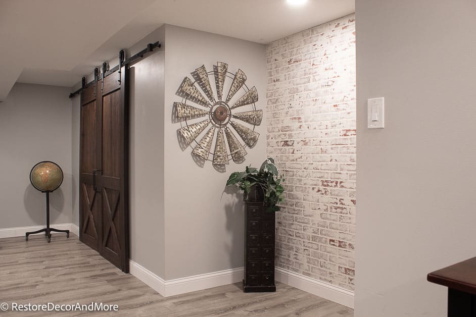 Globe on stand, double barn doors and faux brick wall in finished basement