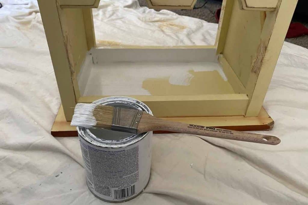 can of white chalk paint with brush on top