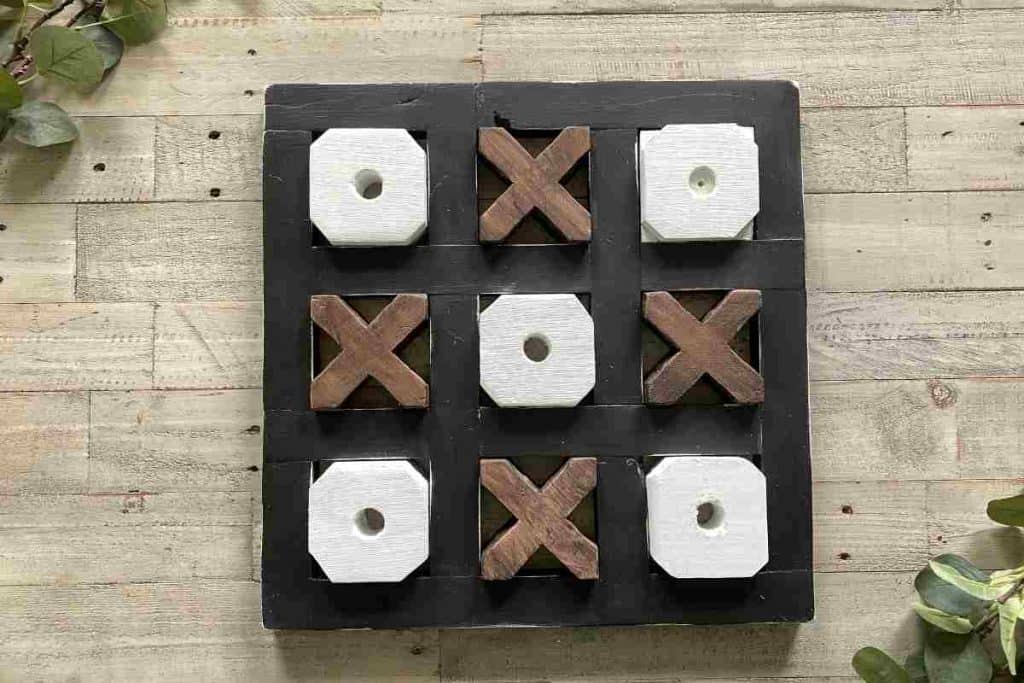 Table top wooden tic tac toe board with black frame white o's and brown x's