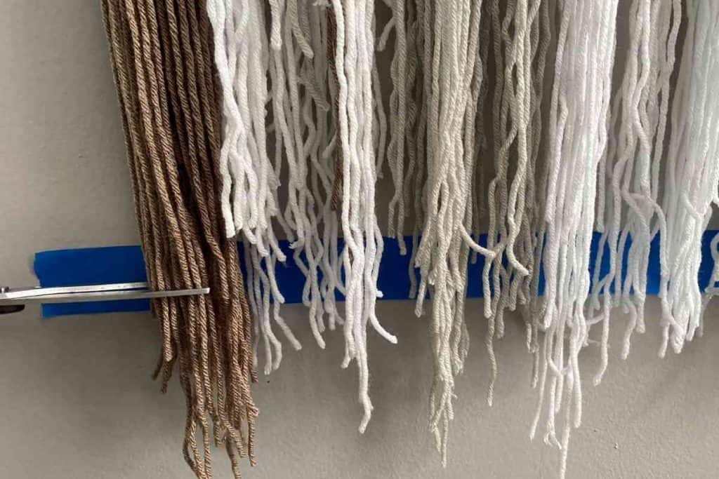 Trim across bottom of yarn wall hanging