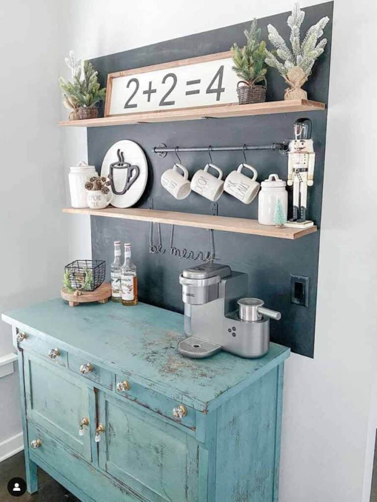green chippy painted coffee bar dresser with black chalkboard on wall, hanging shelves, and coffee decor