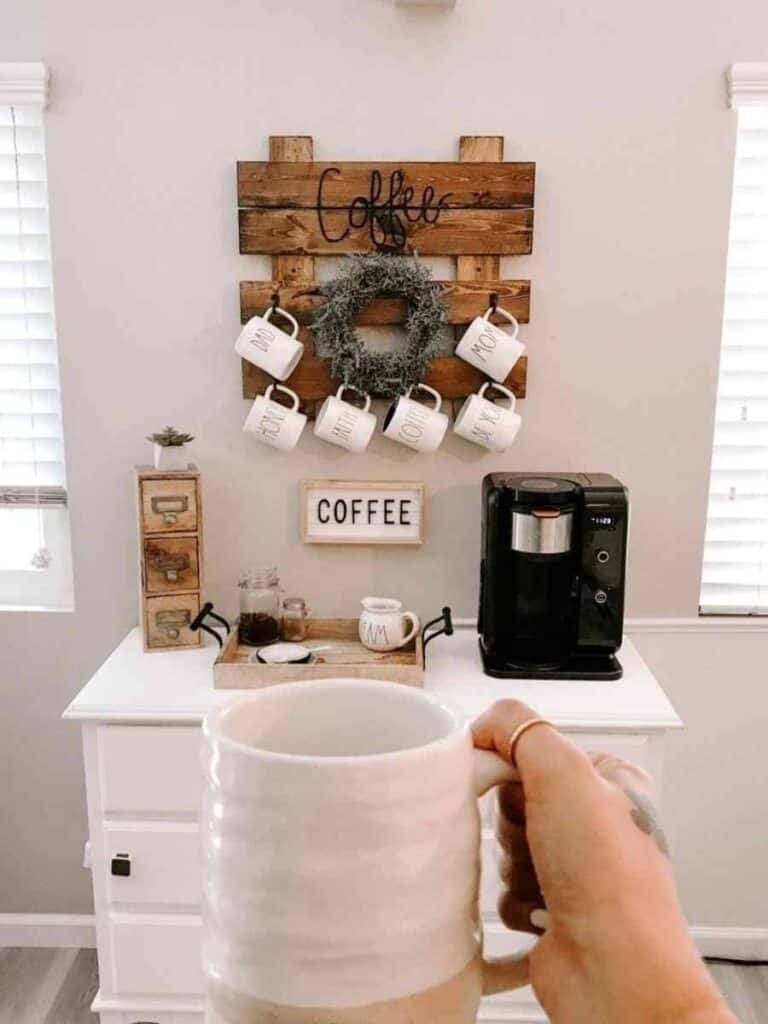 coffee station on dresser with pallet sign and hanging mugs