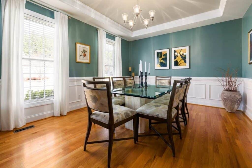 teal walls in dining room with wood floors and furniture