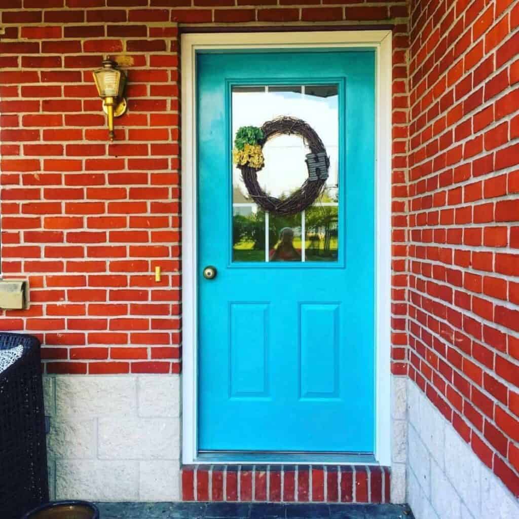 teal front door on red brick house
