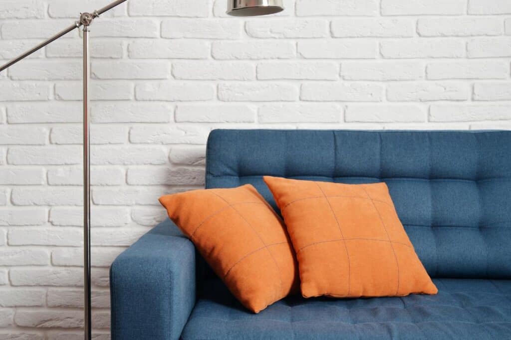 navy blue sofa with burnt orange pillows