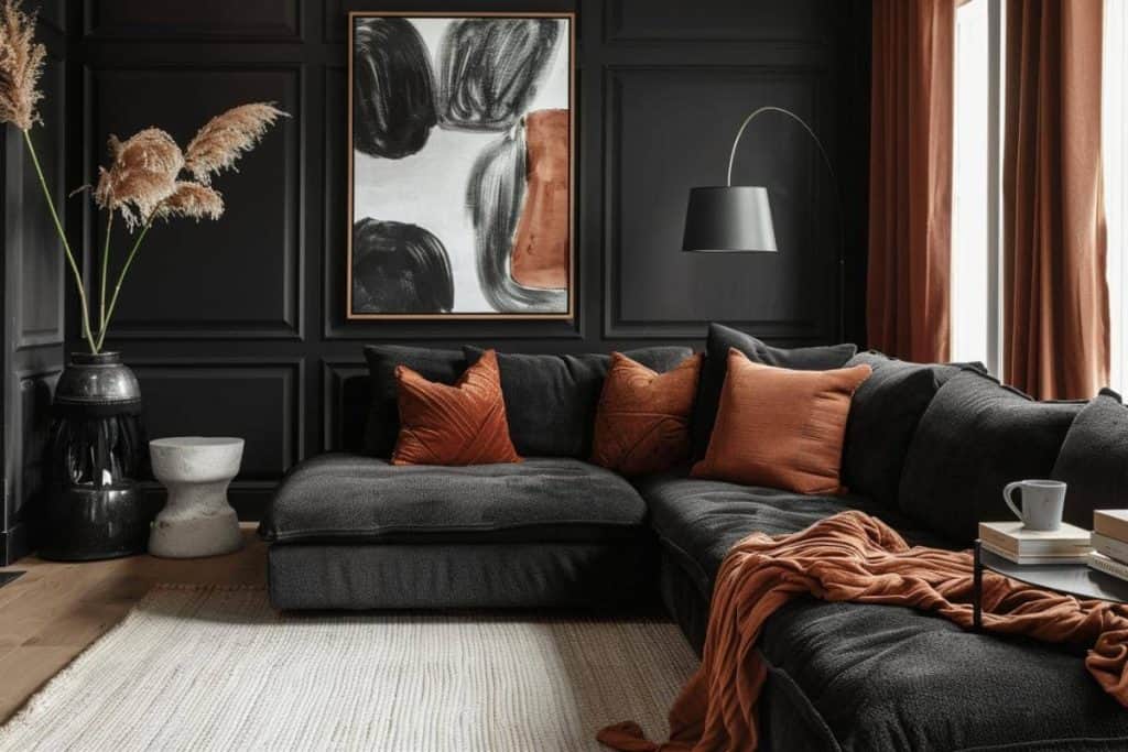 Dark and cozy living space with a black sectional sofa adorned with rust pillows, a central round table, and abstract art on a panelled wall with rust drapes.
