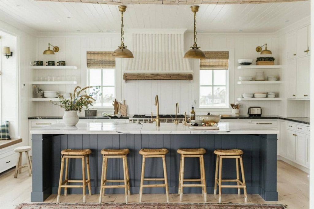 A spacious kitchen with navy blue lower cabinets, two brass pendant lights, and a white shiplap wall with floating shelves.
