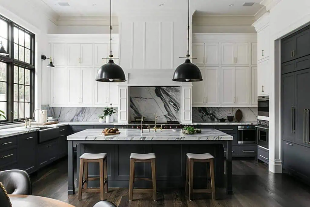 Elegant kitchen with two-toned cabinets, black central island and white perimeter cabinets, marble countertops, and pendant lights over the island.